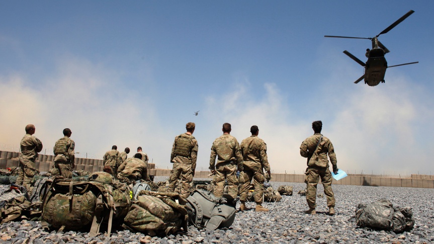 U.S. Army soldiers from the 1-320 Field Artillery Regiment, 101st Airborne Division, watch helicopters at Combat Outpost Terra Nova